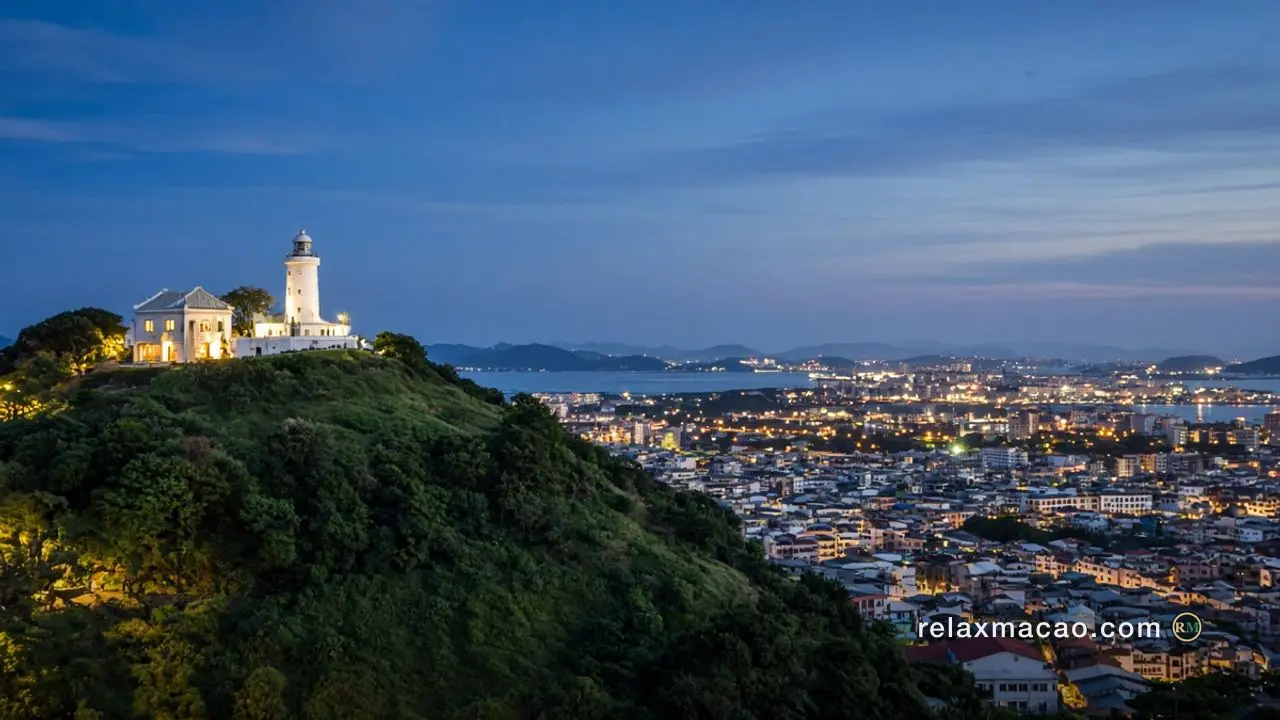 Guia Hill at dusk, the white lighthouse and small chapel on the summit, rooftops of the Macau peninsula lighting up below